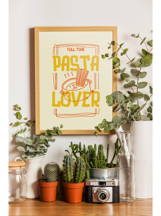 a framed poster with the text "Full Time Pasta Lover" above a graphic of pasta, surrounded by potted plants and a camera on a wooden surface.