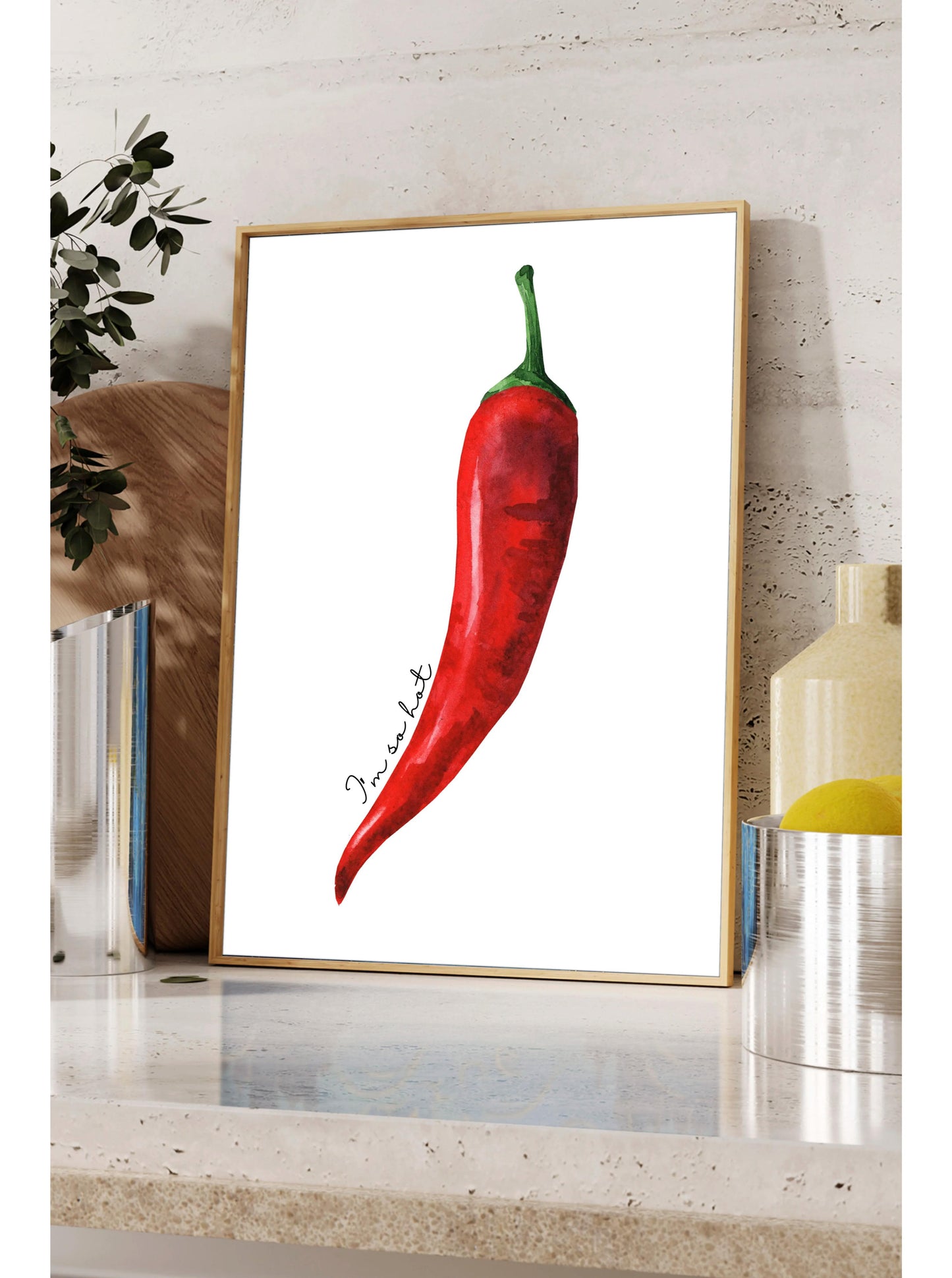 a framed print of a red chili pepper on a shelf.