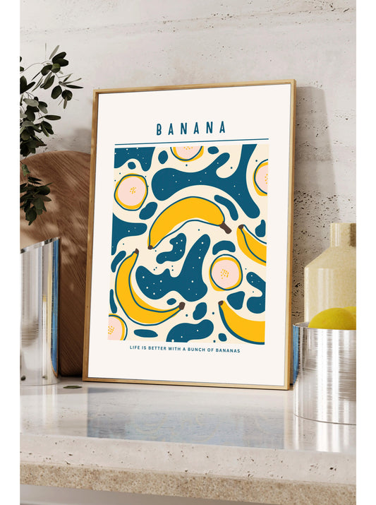 A framed poster with a vibrant design of bananas and other fruits, placed on a shelf next to a plant and a bottle.